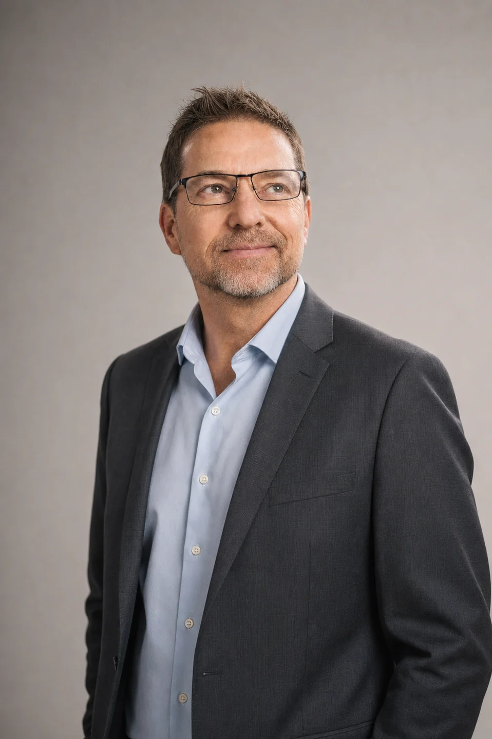 Dennis Barber wearing a charcoal sport coat in a professional studio portrait
